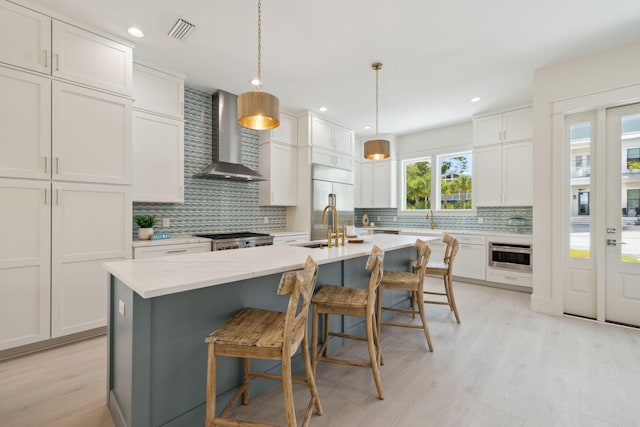 144 Dalton Dr, Santa Rosa Beach, FL 32459 - kitchen with a center island with sink, visible vents, wall chimney range hood, and tasteful backsplash