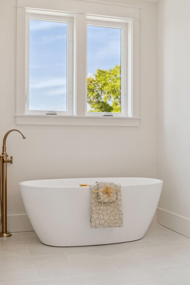 144 Dalton Dr, Santa Rosa Beach, FL 32459 - bathroom with a freestanding tub, tile patterned floors, and baseboards