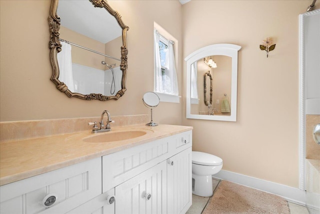 bathroom featuring vanity, baseboards, and toilet