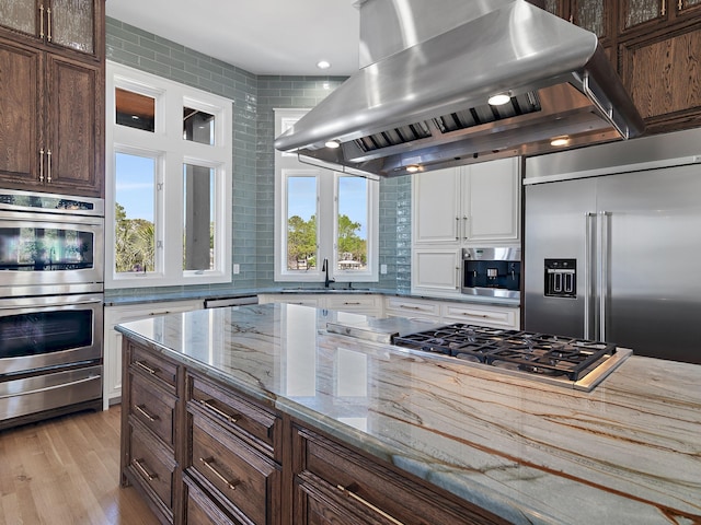 182 My Way, Santa Rosa Beach, FL 32459 - kitchen featuring stainless steel appliances, white cabinetry, island range hood, tasteful backsplash, and a warming drawer
