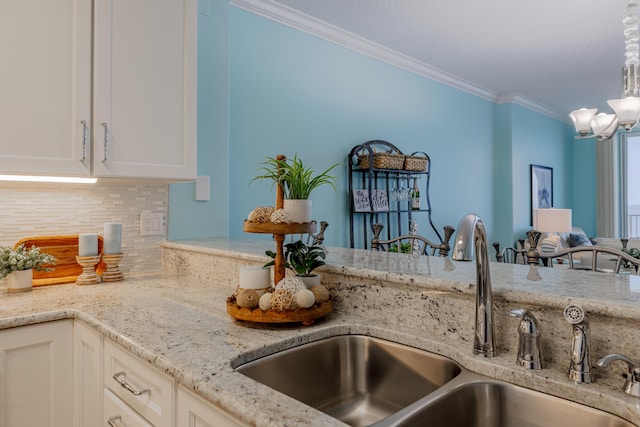 17545 Front Beach Rd Unit 1507, Panama City Beach, FL 32413 - kitchen with crown molding, a chandelier, tasteful backsplash, light stone countertops, and white cabinets