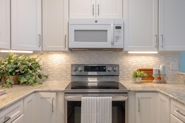 17545 Front Beach Rd Unit 1507, Panama City Beach, FL 32413 - kitchen featuring white microwave, stainless steel range with electric stovetop, white cabinets, and decorative backsplash