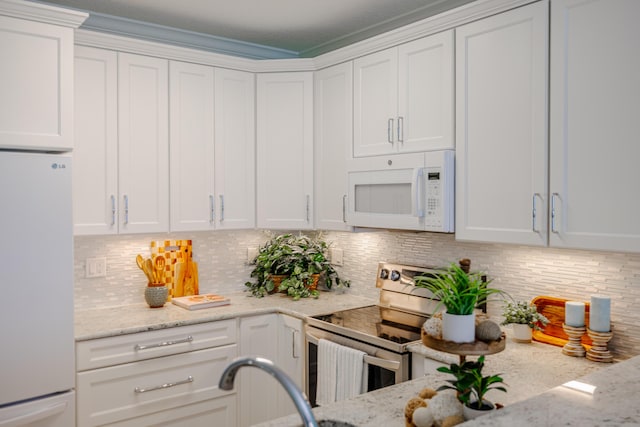 17545 Front Beach Rd Unit 1507, Panama City Beach, FL 32413 - kitchen featuring white appliances, white cabinets, decorative backsplash, and light stone countertops