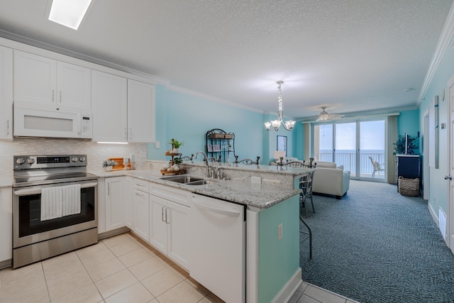 17545 Front Beach Rd Unit 1507, Panama City Beach, FL 32413 - kitchen with white appliances, ornamental molding, a peninsula, open floor plan, and white cabinets