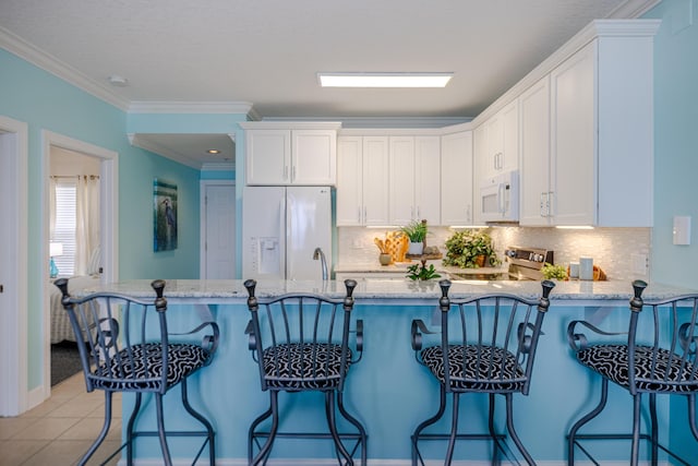 17545 Front Beach Rd Unit 1507, Panama City Beach, FL 32413 - kitchen with white appliances, light stone counters, white cabinets, and crown molding