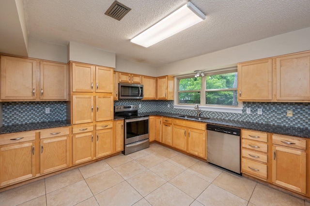 11 Birch Ave, Shalimar, FL 32579 - kitchen featuring a textured ceiling, decorative backsplash, a sink, appliances with stainless steel finishes, and visible vents