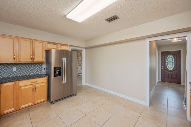 11 Birch Ave, Shalimar, FL 32579 - kitchen with light tile patterned floors, visible vents, stainless steel refrigerator with ice dispenser, baseboards, and a textured ceiling