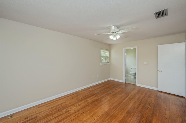 11 Birch Ave, Shalimar, FL 32579 - unfurnished bedroom with wood finished floors, ensuite bath, ceiling fan, baseboards, and visible vents
