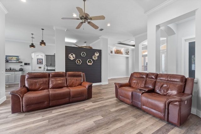 129 Red Maple Way, Niceville, FL 32578 - living room featuring a ceiling fan, crown molding, light wood-style floors, baseboards, and arched walkways
