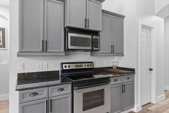 129 Red Maple Way, Niceville, FL 32578 - kitchen featuring stainless steel appliances, gray cabinets, light wood-type flooring, and dark stone countertops