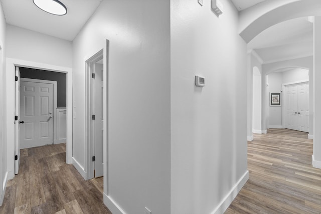 129 Red Maple Way, Niceville, FL 32578 - corridor featuring arched walkways, wood finished floors, and baseboards