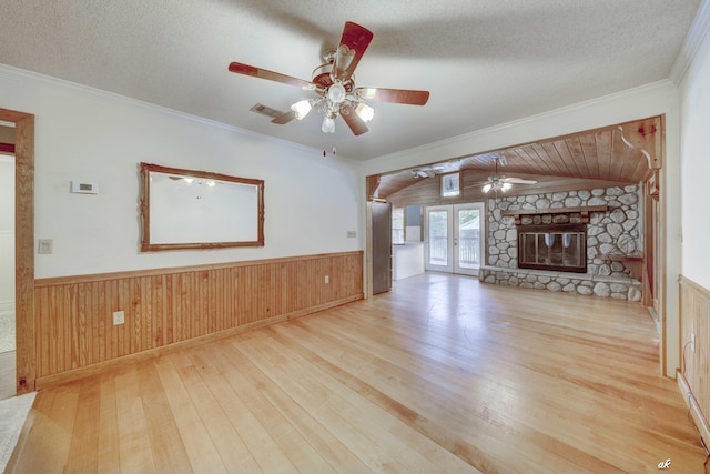 7930 Bunker Rd, Vernon, FL 32462 - unfurnished living room with hardwood / wood-style floors, ceiling fan, a wainscoted wall, a stone fireplace, and crown molding