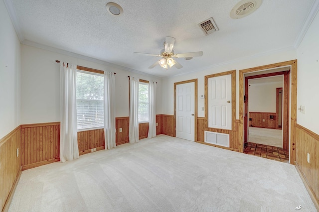 7930 Bunker Rd, Vernon, FL 32462 - unfurnished bedroom with wainscoting, wood walls, ornamental molding, carpet flooring, and a ceiling fan