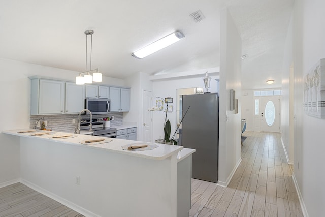 119 Red Bay Ct, Santa Rosa Beach, FL 32459 - kitchen with stainless steel appliances, light countertops, decorative backsplash, light wood finished floors, and lofted ceiling