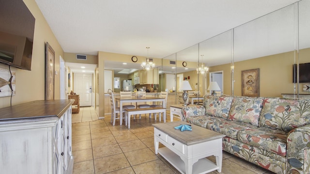 living room with visible vents, an inviting chandelier, and light tile patterned flooring