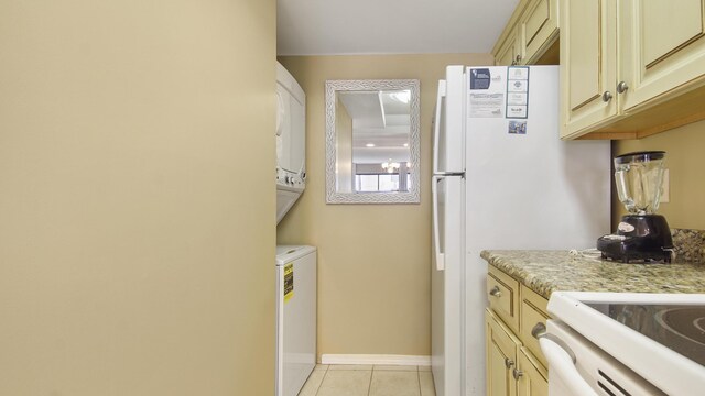 520 N Richard Jackson Blvd Unit 952, Panama City Beach, FL 32407 - washroom featuring baseboards, stacked washing maching and dryer, light tile patterned flooring, and laundry area