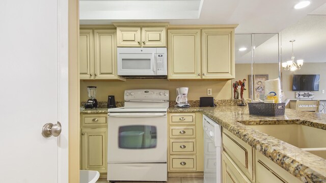 520 N Richard Jackson Blvd Unit 952, Panama City Beach, FL 32407 - kitchen with light stone counters, cream cabinetry, white appliances, and hanging light fixtures