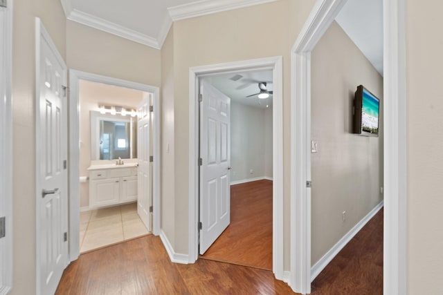 229 Inverrary Dr, Destin, FL 32541 - hall featuring crown molding, baseboards, wood finished floors, and a sink