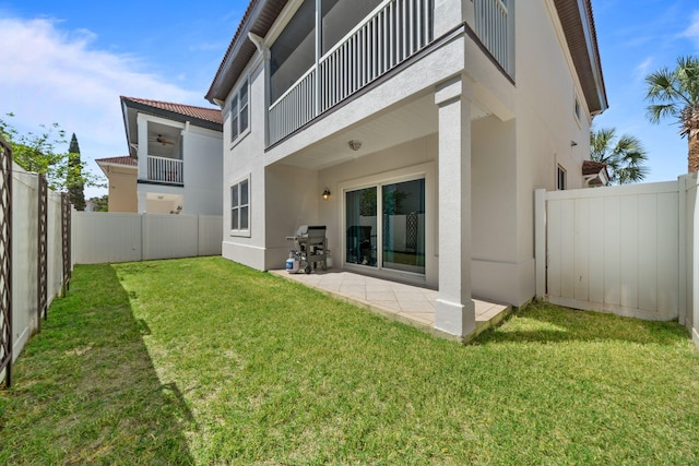 229 Inverrary Dr, Destin, FL 32541 - rear view of property featuring a fenced backyard, a yard, stucco siding, and a balcony