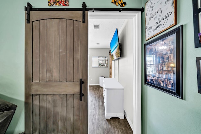 2542 Edgewood Dr, Navarre, FL 32566 - entryway with a barn door, dark wood-style floors, baseboards, and a textured ceiling