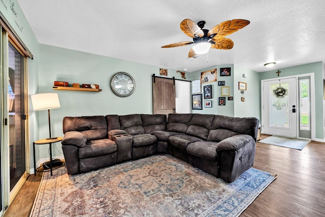 2542 Edgewood Dr, Navarre, FL 32566 - living room with a barn door, ceiling fan, wood finished floors, and baseboards