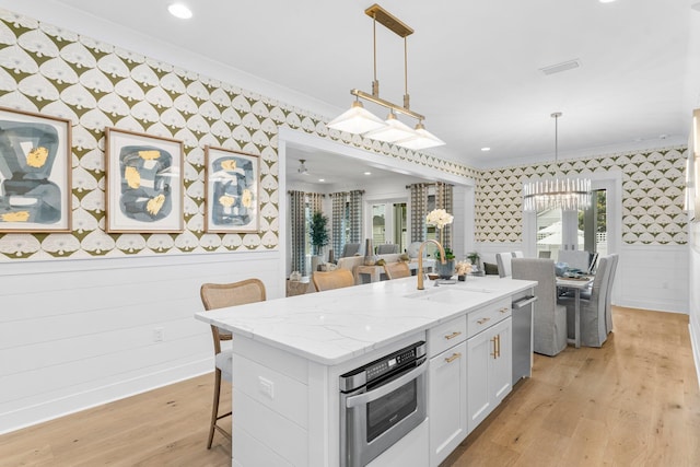 10 Basal St, Inlet Beach, FL 32461 - kitchen with wallpapered walls, crown molding, a sink, appliances with stainless steel finishes, and a kitchen breakfast bar