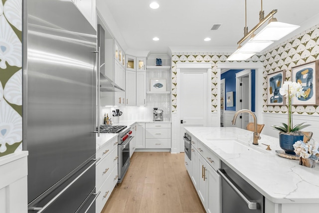 10 Basal St, Inlet Beach, FL 32461 - kitchen with premium appliances, a sink, white cabinetry, light wood finished floors, and glass insert cabinets