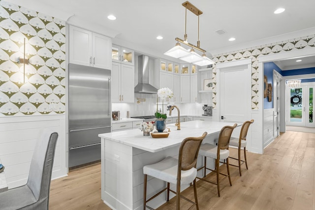 10 Basal St, Inlet Beach, FL 32461 - kitchen featuring stainless steel appliances, wall chimney exhaust hood, light wood-style floors, open shelves, and white cabinets