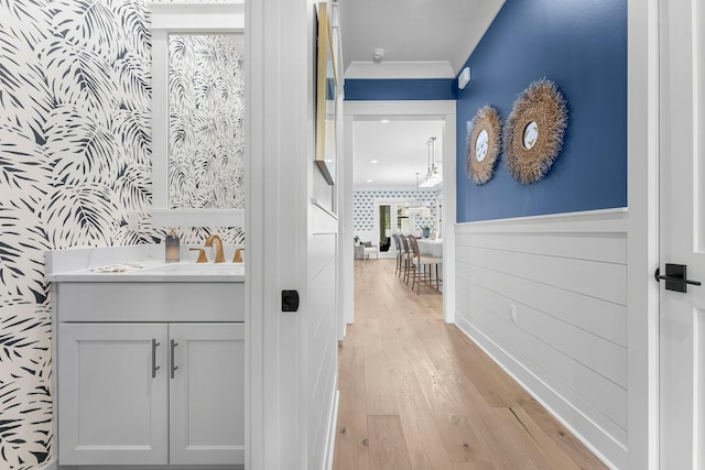10 Basal St, Inlet Beach, FL 32461 - hallway featuring wallpapered walls, light wood-style floors, wainscoting, crown molding, and a sink