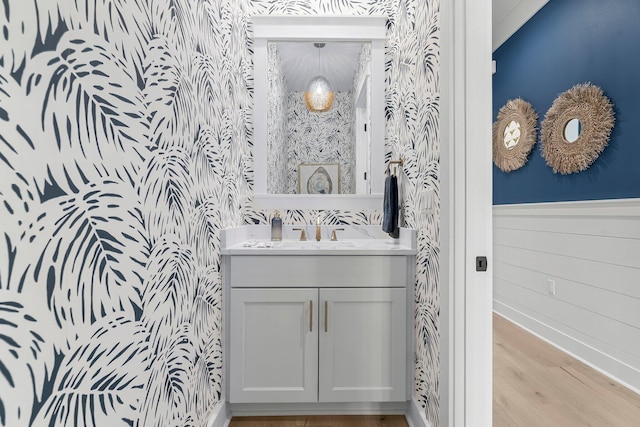 10 Basal St, Inlet Beach, FL 32461 - bathroom featuring wallpapered walls, wood finished floors, vanity, a wainscoted wall, and baseboards