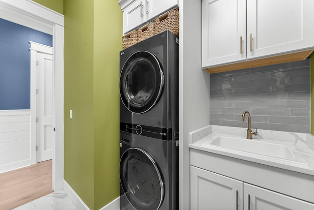 10 Basal St, Inlet Beach, FL 32461 - laundry area with stacked washer / dryer, cabinet space, and light marble finish flooring