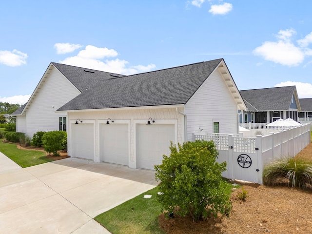 10 Basal St, Inlet Beach, FL 32461 - view of side of property with an attached garage, driveway, a shingled roof, and fence