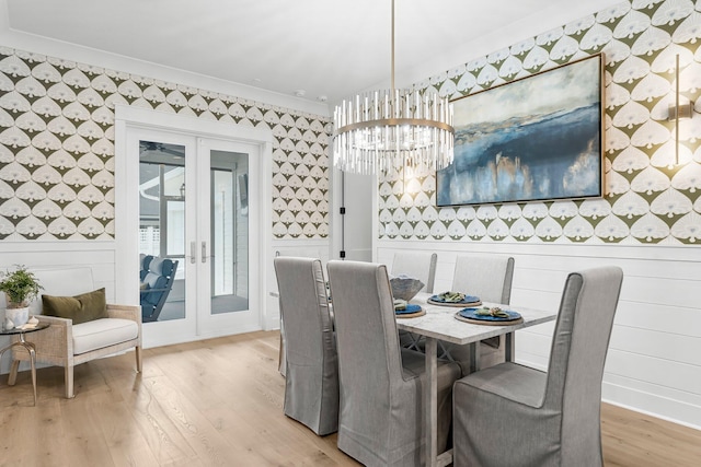 10 Basal St, Inlet Beach, FL 32461 - dining space with wallpapered walls, french doors, light wood finished floors, a chandelier, and crown molding