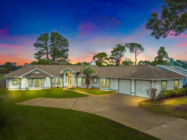ranch-style home featuring concrete driveway, a front lawn, and a garage