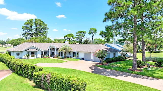 ranch-style home with a garage, a chimney, a front lawn, and concrete driveway