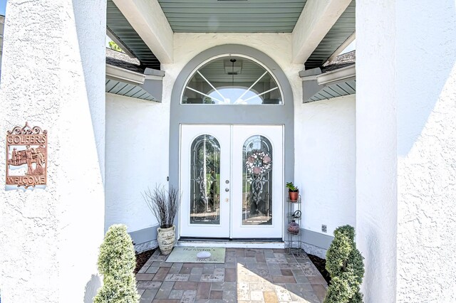 doorway to property featuring stucco siding and french doors
