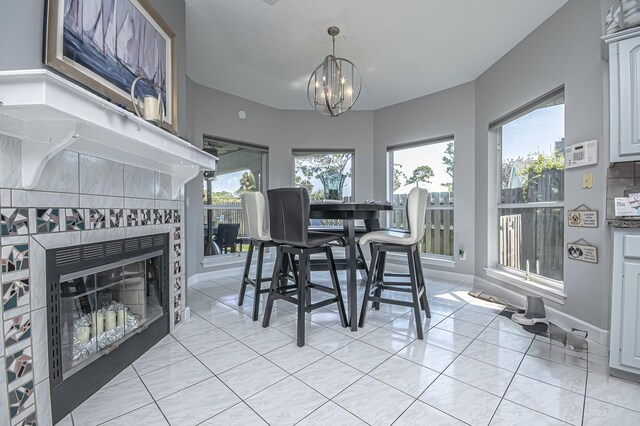 dining room with an inviting chandelier, a tile fireplace, and baseboards