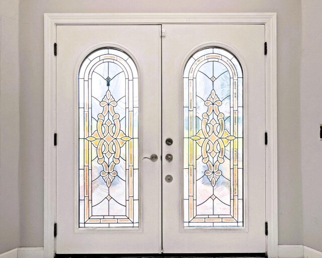 foyer entrance with french doors and baseboards