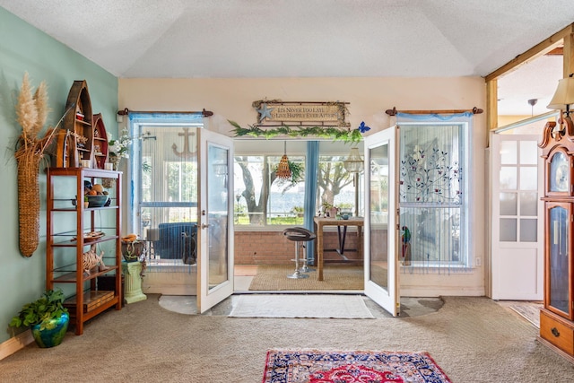 entryway with lofted ceiling, carpet, french doors, and a textured ceiling