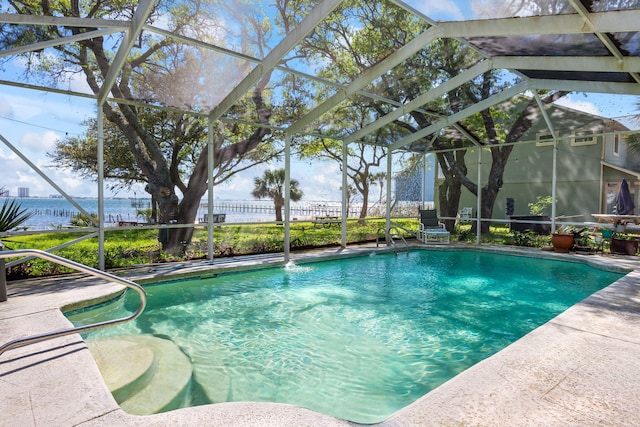 outdoor pool with a lanai, a water view, and a patio