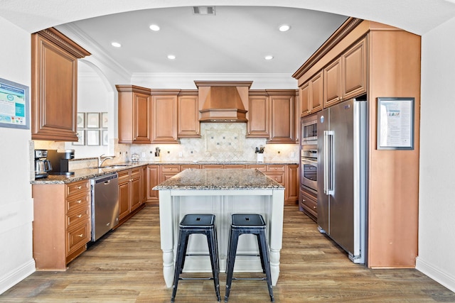 48 Tranquility Ln, Destin, FL 32541 - kitchen featuring custom exhaust hood, arched walkways, stone countertops, and stainless steel appliances