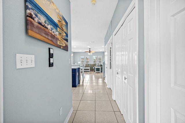 hall featuring light tile patterned floors, recessed lighting, and baseboards