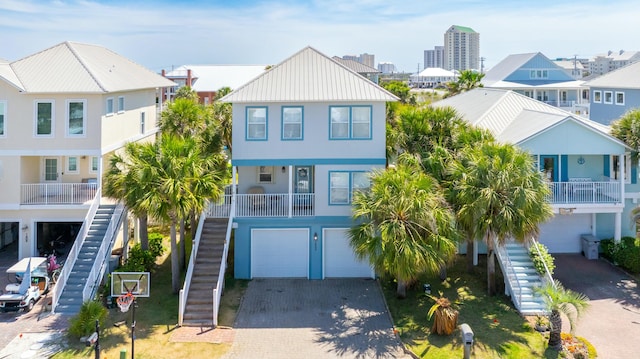beach home featuring stairway, decorative driveway, a residential view, and a garage