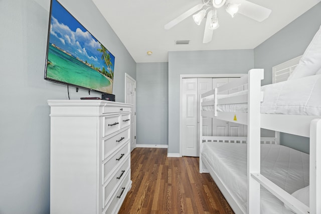 unfurnished bedroom featuring dark wood-style flooring, a closet, a ceiling fan, visible vents, and baseboards