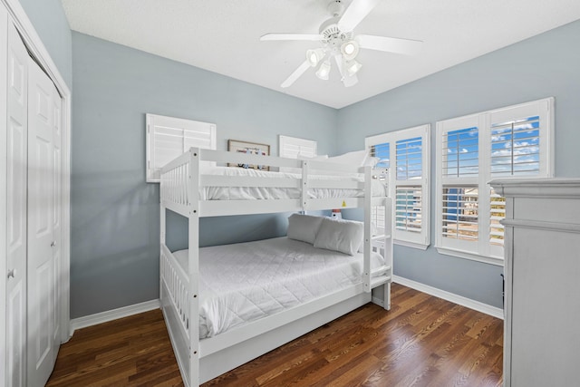 bedroom featuring a closet, ceiling fan, wood finished floors, and baseboards
