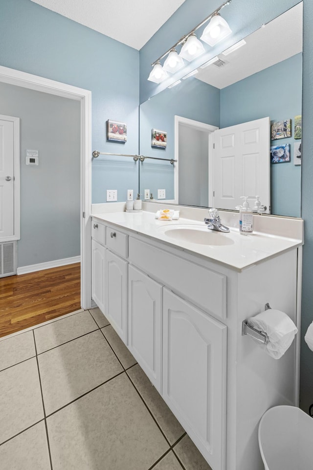 bathroom with baseboards, visible vents, tile patterned flooring, and vanity