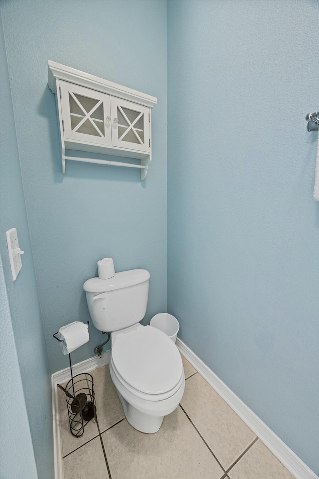 bathroom featuring toilet, tile patterned flooring, and baseboards