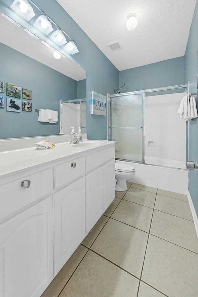 bathroom featuring visible vents, enclosed tub / shower combo, toilet, tile patterned floors, and vanity