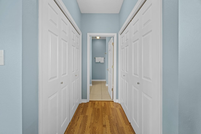 hallway with baseboards and wood finished floors
