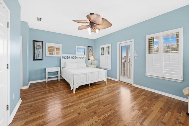 bedroom with wood finished floors, visible vents, access to outside, and baseboards